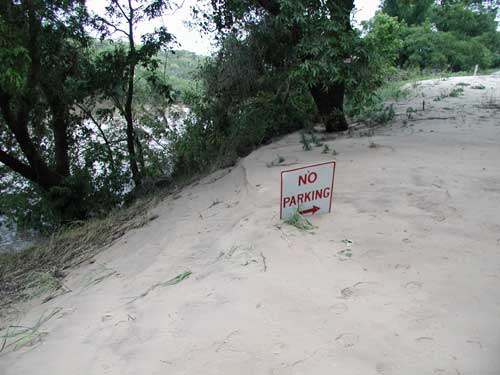 No parking sign covered by sand