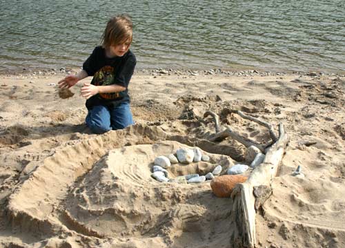 Zac tossing sand from beach sculpture